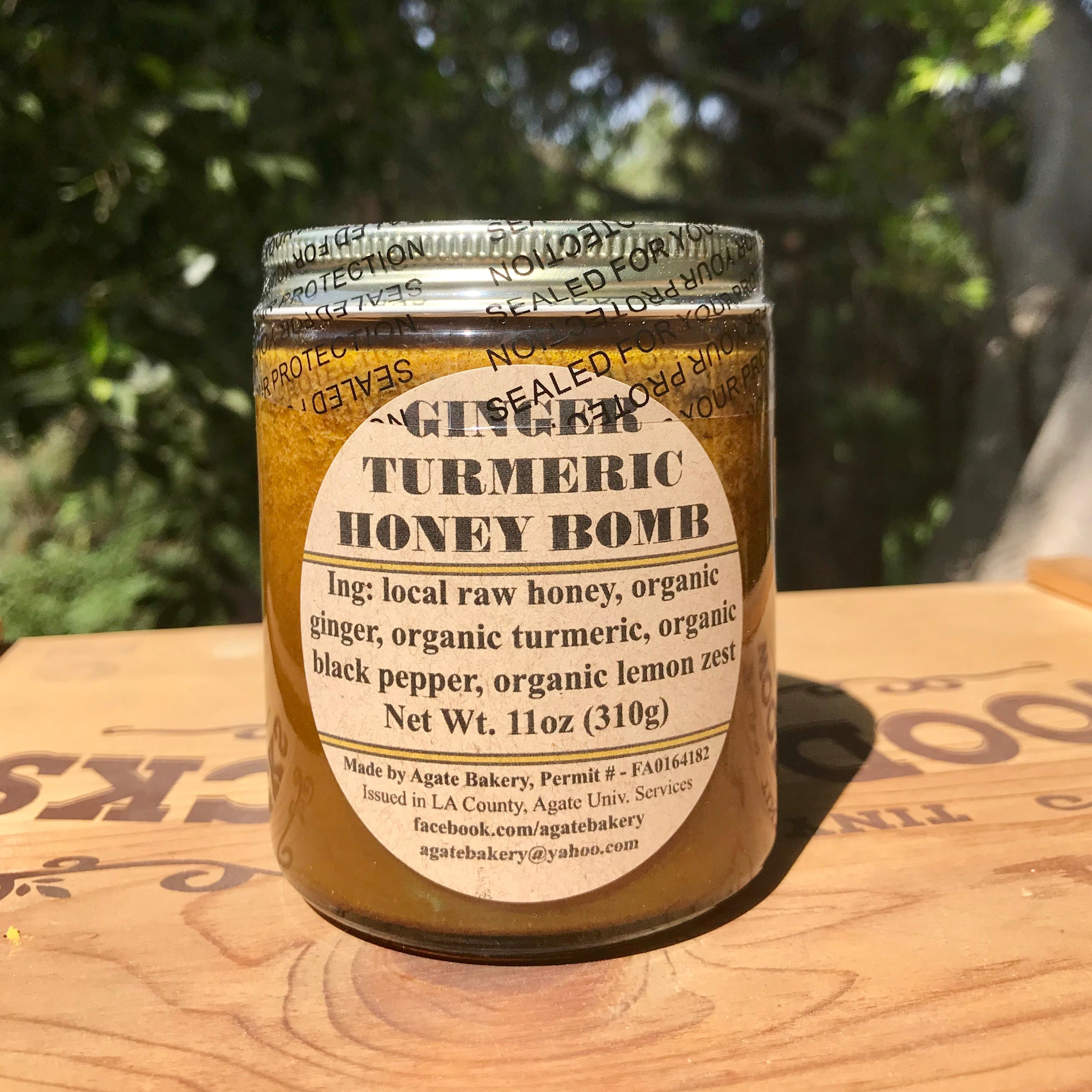 Jar of Turmeric Honey Bomb on a wooden surface with a natural background